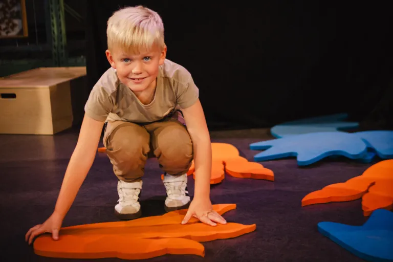 Jonge bezoeker legt dino pootafdruk op de grond